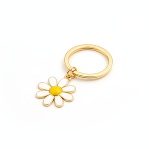 key chain that is gold with a daisy attached to it